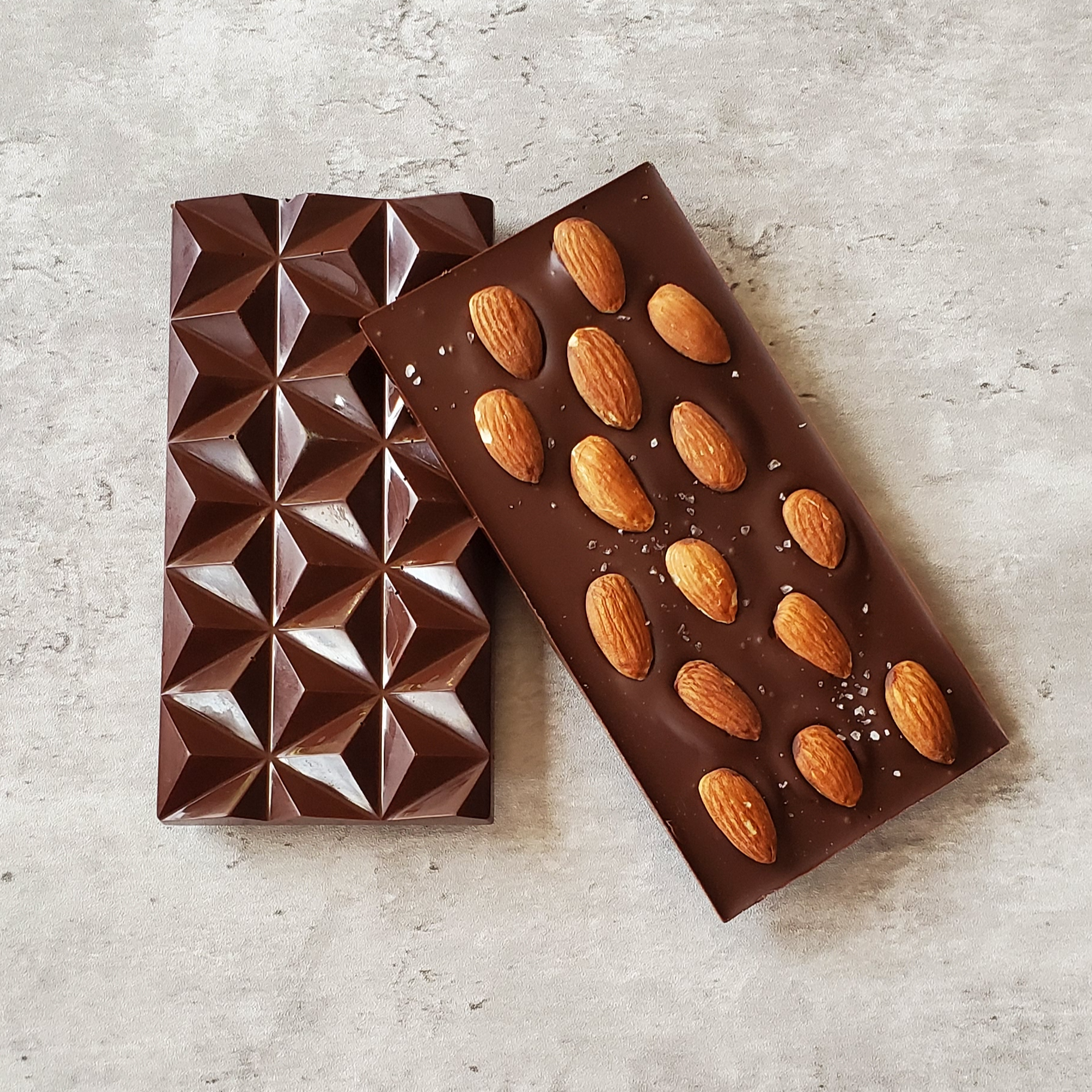 Dark chocolate bar, textured pattern, with almonds, sprinkled with fleur de sel 